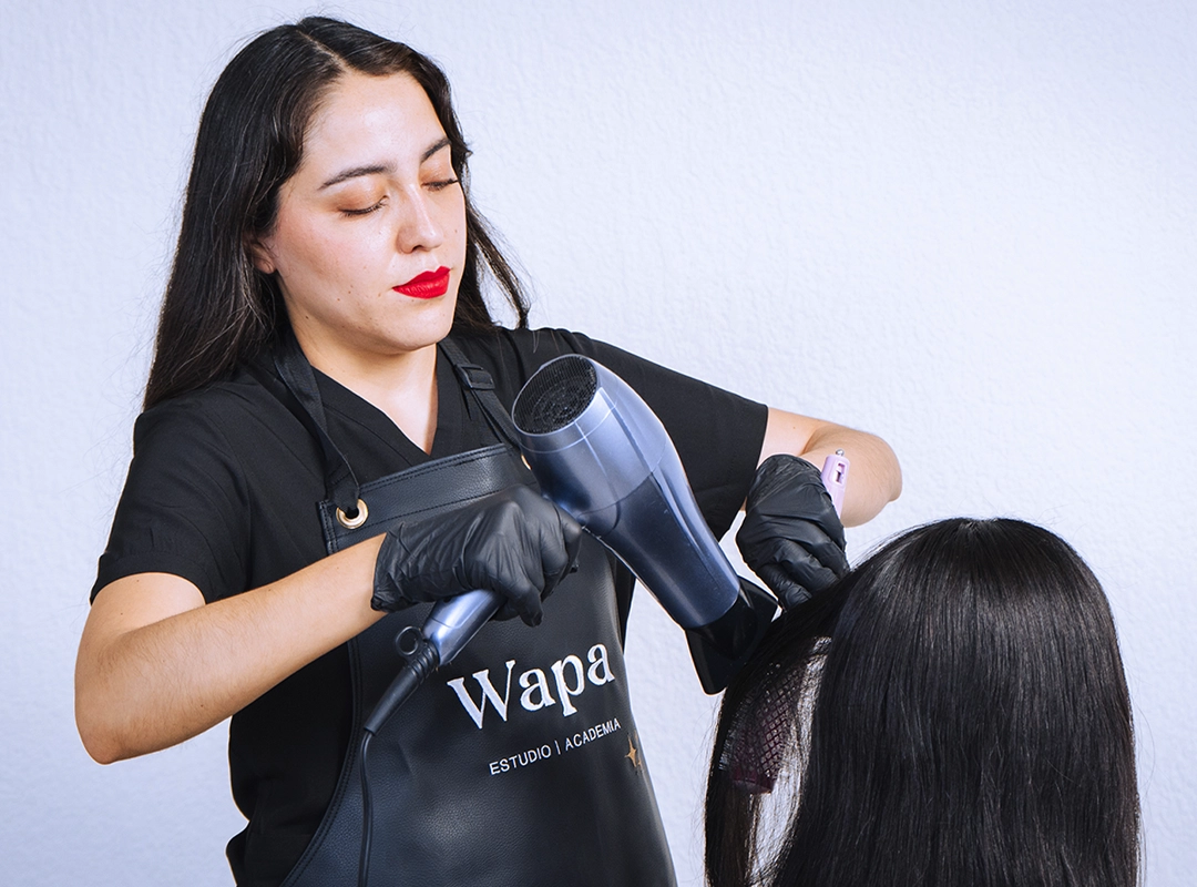 Foto de la maestra del curso de Wapa Studio con una secadora de cabello